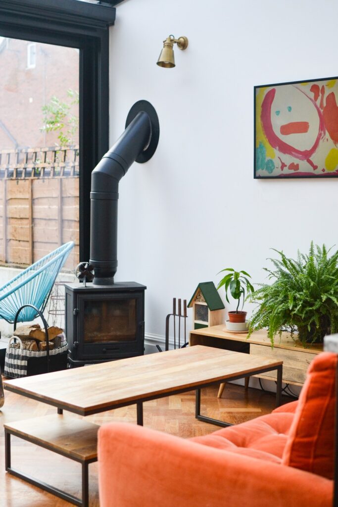 Living room with log burner and orange velvet sofa.