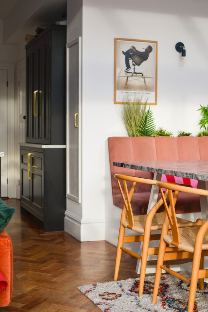 Pink velvet seating area in kitchen with parquet floors. Carl Hansen Wishbone chairs.